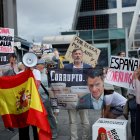 Los manifestantes sostienen una efigie de Begoña Gómez y una pancarta que dice "España corrupta" mientras la esposa del primer ministro español.
