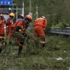 Bomberos limpian una carretera de ramas de árboles después del paso del tifón Ragasa en la isla Hailing,provincia de Guandong, China, el 25 de septiembre de 2025.