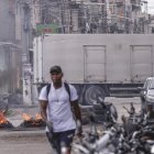 Una persona camina frente a barricadas en llamas durante un operativo policial este viernes, en Río de Janeiro (Brasil)