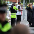 El primer ministro, Keir Starmer, y su esposa, Victoria, hablan con agentes de la Policía mientras visitan la escena frente a la sinagoga de la Congregación Hebrea de Heaton Park.