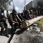 Policías retiran un tronco de la carretera, que fue puesto por los que quieren que el diésel tenga subsidio.