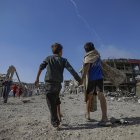 Palestinos caminan por una calle entre los escombros de edificios destruidos durante un alto el fuego entre Israel y Hamás en virtud de la primera fase del plan de paz de Gaza.