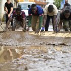 Varias personas trabajan en la limpieza de las calles durante la mañana de este lunes cuando la dana que desde ayer azota el sur de Cataluña.