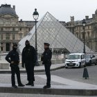 Agentes de policía franceses se sitúan frente al Museo del Louvre tras un robo, en París, este domingo 19 de octubre de 2025.