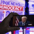 Fotografía de archivo de un espectador que graba en su teléfono, la entrevista del presidente Donald Trump.