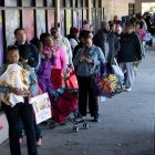 La gente hace fila para recibir alimentos para los trabajadores federales suspendidos en No Limits Outreach Ministries el 21 de octubre de 2025 en Hyattsville, Maryland.