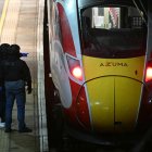 Agentes de policía inspeccionan el andén junto a un tren en la estación de Huntingdon, en el este de Inglaterra, este sábado 1 de noviembre, tras un ataque con arma blanca.