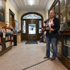 Sylvie Boudreau, presidenta de la junta directiva de la biblioteca transfronteriza Haskell, posa para una fotografía de pie sobre el marcador negro que indica los lados de EE. UU. (izq.) y Canadá, dentro de la biblioteca.