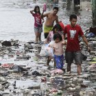 Un grupo de niños camina por las calles inundadas de Manila, Filipinas este lunes tras el paso del tifón Fung-Wong.