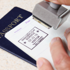 Referencial.Funcionario colocando el sello de ingreso en un pasaporte, en un control migratorio.