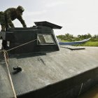 Fotografía de un soldado de la Armada Nacional de Colombia al inspeccionar un submarino utilizado por grupos delictivos.