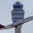 Fotografía de un avión Delta Air Lines pasando por la torre de control del Aeropuerto Internacional Hartsfield-Jackson, en Atlanta (Estados Unidos).