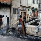 Un integrante de la Policía de Río de Janeiro custodia a dos personas durante un operativo , en Río de Janeiro (Brasil).