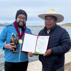 El ultranadador ecuatoriano Juan Pablo Flores (i) recibió un certificado por haber completado los 21 kilómetros entre la ruta Gruta de Lourdes (Bolivia) - Pomata (Perú).