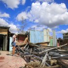 Destrucción. Una mujer observa con tristeza los restos de su casa destruida días antes por el huracán Melissa en El Cobre, Santiago de Cuba. Hay miles de damnificados.
