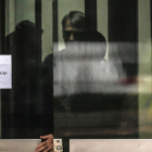 Bolsonaro aparece tras una puerta en la Policía Federal de Brasilia, donde explicó que quemó su tobillera electrónica tras sufrir “paranoia” por medicamentos.