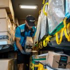 Un trabajador de la empresa Amazon organiza paquetes que se deben entregar.