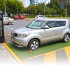 Un carro eléctrico se carga de energía en un parqueadero.