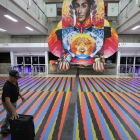 Pasajero camina frente a una imagen de Simón Bolívar en el aeropuerto de Maiquetía durante el plazo otorgado a las aerolíneas para retomar operaciones.