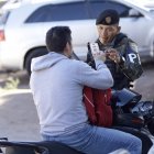 Un integrante de la Policía Militar de Honduras revisa el documento de un ciudadano en Tegucigalpa.