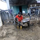 Residentes intentan limpiar su casa del barro en la zona de Meureudu , en banda Aceh, Indonesia.