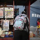 Una mujer se encuentra frente a un quiosco que muestra las portadas de los periódicos en Tegucigalpa, el 1 de diciembre de 2025, el día después de las elecciones nacionales.