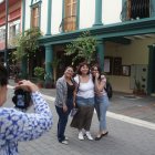 Las personas inmortalizan a la ciudad junto a sus recuerdos en una fotografía al aire libre.