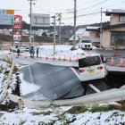 Un automóvil quedó varado en una carretera colapsada en Tohoku, prefectura de Aomori, noreste de Japón, el 9 de diciembre de 2025.