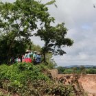 Personas observan una zona afectada por el desbordamiento de un río este domingo 14 de diciembre, en El Torno (Bolivia).