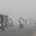 Vehículos transitan por calles en Nueva Delhi con poca visibilidad debido a la contaminación del aire en India.
