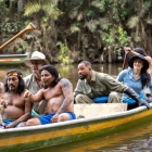 Integrantes de Nat Geo navegan junto a la comunidad Waorani en una embarcación tradicional amazónica.