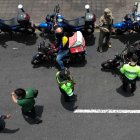 Agentes de policía registran a motociclistas en un puesto de control después de que el gobierno declarara el estado de emergencia en Lima el 22 de octubre de 2025.