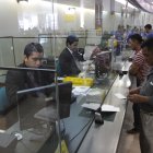 Clientes son atendido en las ventanillas de un banco de Ecuador.