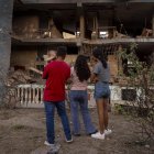 Personas observan un edificio afectado por un explosivo, este 4 de enero de 2026 en Catia La Mar (Venezuela).