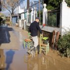 Un vecino en el sur de España, limpia de lodo y barro el interior de su vivienda ante la crecida del río Guadalhorce y las precipitaciones intensas tras decretarse la alerta roja.