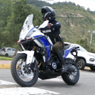 Un agente de la Policía Nacional patrulla en motocicleta una zona montañosa de Ecuador, en labores de vigilancia preventiva.