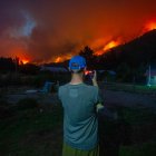 Un hombre toma una fotografía de los incendios forestales este miércoles, en el Hoyo provincia de Chubut (Argentina).