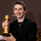 Timothee Chalamet posa con el premio a la mejor interpretación masculino en una película - musical o comedia por "Marty Supreme".