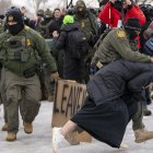 Un integrante de la Policía detiene a una persona durante las protestas en Mineápolis contra el Servicio de Inmigración y Control de Aduanas (ICE).