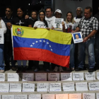 Familiares de presos políticos en Venezuela sostienen carteles en una vigilia, afuera de El Helicoide en Caracas.