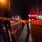 Agentes federales y policías antidisturbios detrás de cinta policial mientras estallan protestas tras el tiroteo de un hombre venezolano por parte de un agente de ICE en Mineápolis, el 14 de enero de 2026.