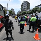 Agentes policiales registran a motociclistas en un puesto de control después de que el gobierno declarara el estado de emergencia en Lima.