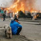 Un hombre observa casas afectadas por incendios forestales este domingo, en Penco (Chile).