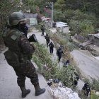 Soldados del Ejército de Guatemala y policías patrullan una calle del barrio Nueva Jerusalén durante el estado de emergencia declarado por el gobierno en la Ciudad de Guatemala el 20 de enero de 2026.