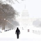 Un hombre camina por el National Mall mientras cae nieve en Washington, DC, el 25 de enero de 2026.
