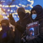 La gente llora en un monumento improvisado en el área donde Alex Pretti, de 37 años, fue asesinado a tiros por agentes federales de inmigración en Mineápolis, el 24 de enero de 2026.