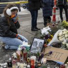 Una residente local se arrodilla y llora mientras visita un monumento improvisado en la zona donde Alex Pretti fue asesinado a tiros por agentes federales de inmigración en Mineápolis.