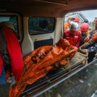 Los rescatistas llevan restos de una víctima en una zona afectada por un deslizamiento de tierra en la aldea de Pasirlangu, Indonesia, el 25 de enero de 2026.