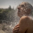 En la imagen de archivo, un hombre se refresca en una ducha en las termas de A Chavasqueira, en Ourense, España.