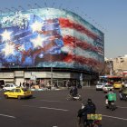 Los vehículos circulan cerca de una enorme valla publicitaria antiestadounidense colgada en la plaza Enqelab en Teherán, Irán, el 27 de enero de 2026.